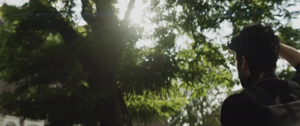 Caucasian man taking pictures outside next to trees