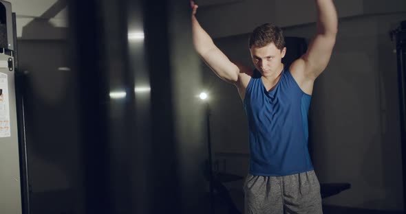 A Man Warms Up Body Makes Circular Swings of Hands in Gym