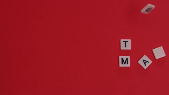 White letter tiles moving to spell out happy christmas on red background