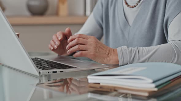 Hands of Senior Woman Video Calling on Laptop