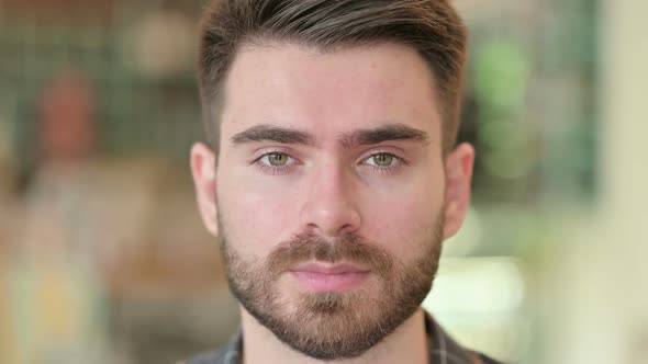 Close Up of Serious Young Man Looking at the Camera