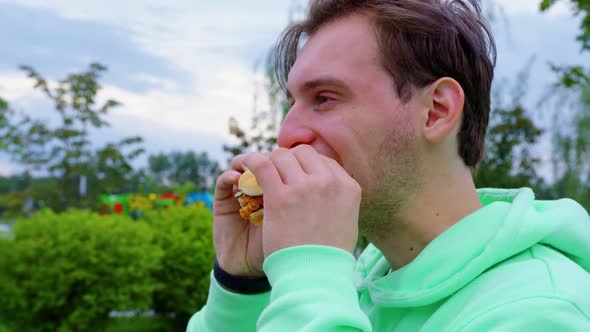 Stubble Guy Bites Off Chews Sandwich in the City Park