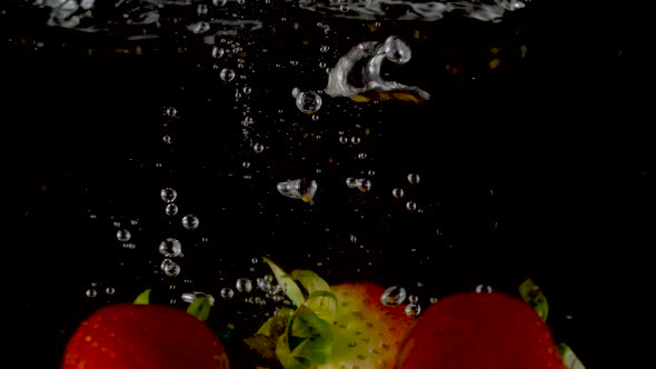 Closeup of fresh and healthy strawberries falling into clear water with big splash