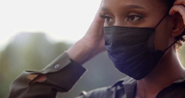 Close Up of Female Human Hands Wearing Black Medical Surgical Face Mask on Makeup and Tanned African