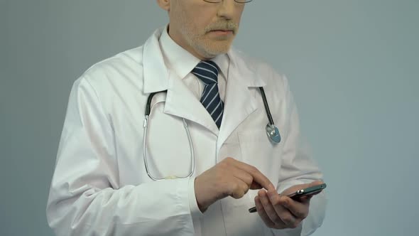 Hospital Physician Dialing Number on Smartphone, Calling to Consult Patient