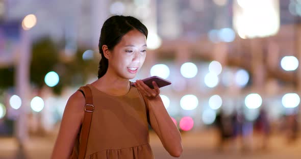 Young Woman use of smart phone in city at night