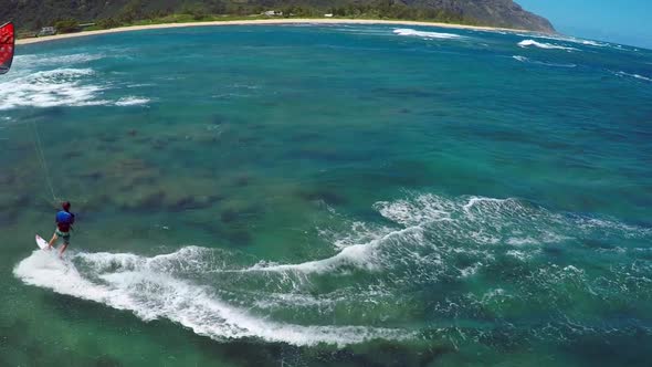 Aerial view of a man kitesurfing in Hawaii.