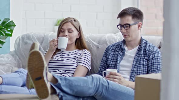 Young Couple Drinking Coffee on Sofa