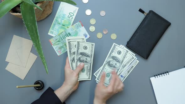 Businesswoman doing calculation for online financial report at workplace, counting cash money