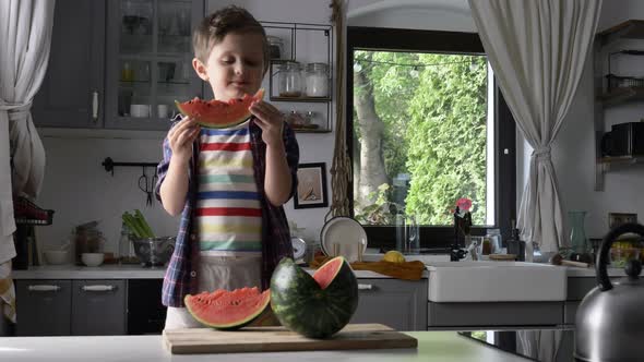 Little kid eating watermelon in kitchen