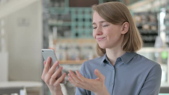 Portrait of Young Woman Reacting to Loss on Smartphone