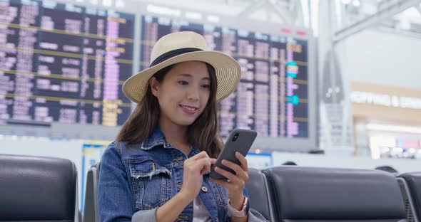 Woman use of mobile phone inside airport