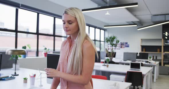 Caucasian businesswoman looking at the camera and smiling in modern office