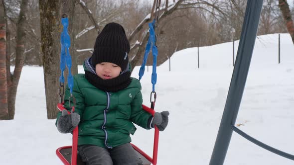 Cute Asian Boy Riding a Swing