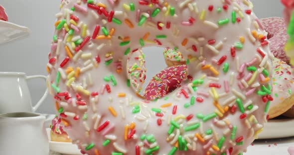 Table with donuts and coffee. Donuts with icing and sprinkles.