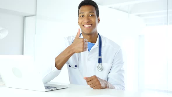 Thumbs Up by Afro-American Doctor in Clinic