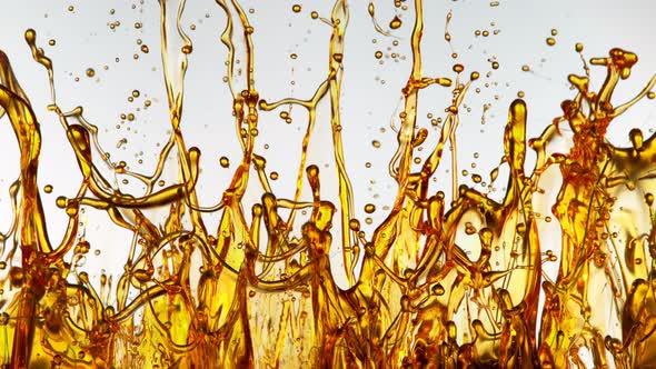 Super Slow Motion Shot of Splashing Golden Oil on White Background at 1000Fps