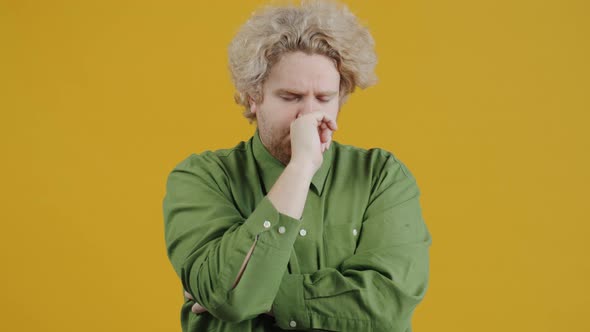 Portrait of Smart Young Man Thinking Then Raising Finger with Great Idea on Yellow Background