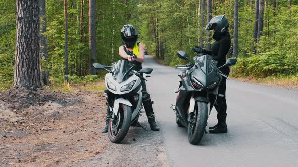 Women Friends Stands Up From the Motorbikes in the Forest