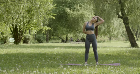 Front View of Woman with Beautiful Athletic Body and Braided Muscles Stretching Raising Her Arms As