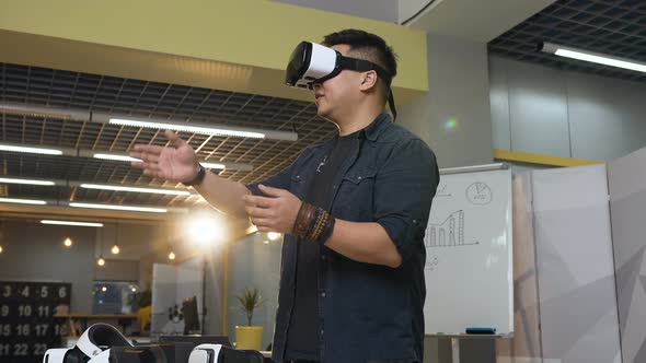 Young Concentrated Man in Virtual Reality VR Glasses Working in the Office