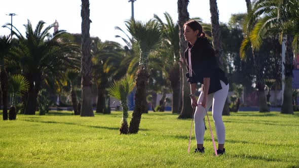 Pretty Lady Working Out with Elastic Band Outdoors