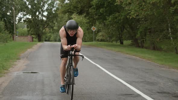 Man Triathlete Rides a Bike Pro Cyclist Rides on a Road Athlete Training for Triathlon Super Slow
