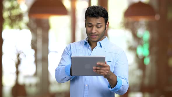 Brownskinned Man Holding Tablet Pc and Greeting with Someone Online