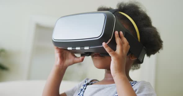 Smiling african american girl playing with vr headset in living room