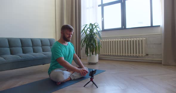 Footage of a Middleaged Man Picking Up an Online Workout Guide for His Home Yoga Workout