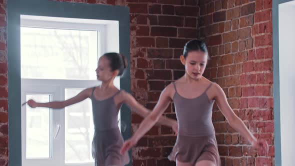 Two Ballerina Girls Performing Basic Dancing Moves in the Studio