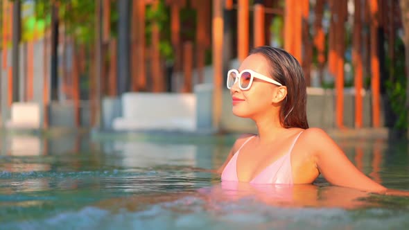 Young asian woman enjoy around outdoor swimming pool for leisure