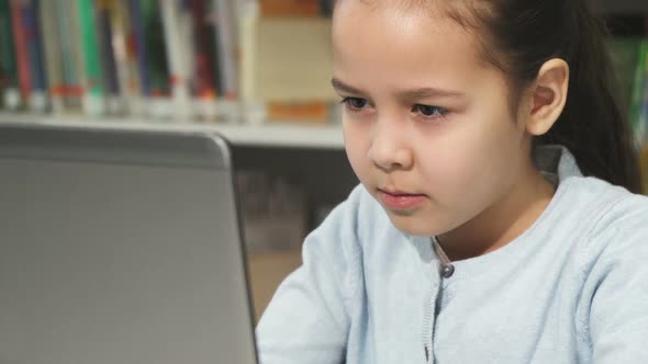 Cute Little Girl Concentrating Using Her Laptop