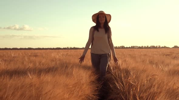 Adult Brunette Wearing Straw Hat Walks Wheat Field