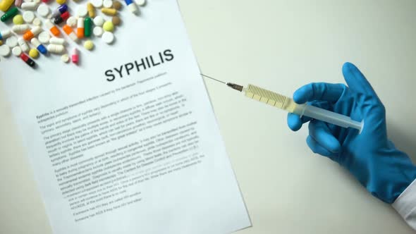 Syphilis Diagnosis Written on Paper Hand Holding Medication in Syringe Treatment