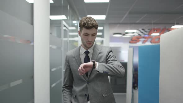 Businessman walking and looking at his watch