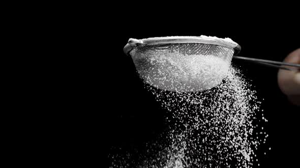 Flour Sifting with Sieve Slow Mo Isolated on Black for Pie or Cupcake Making