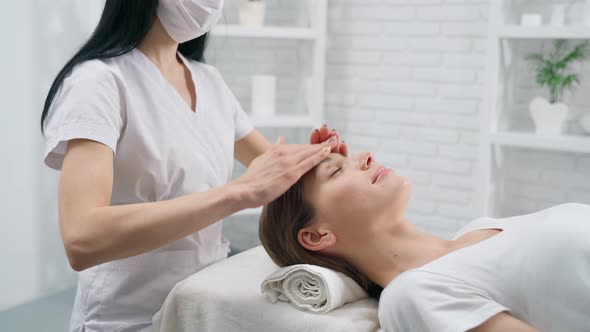 Beautician Doing Face Massage for Young Woman