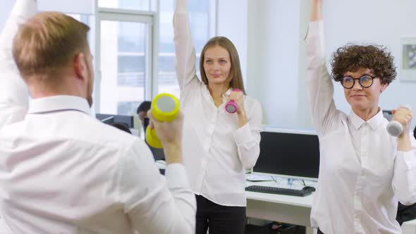 Office Workers Using Dumbbells at Workplace