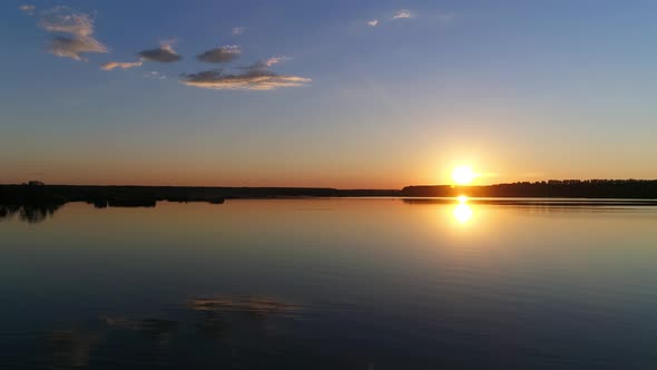 Sunset on a Clear Summer Evening on a Lake or River - Drone Footage