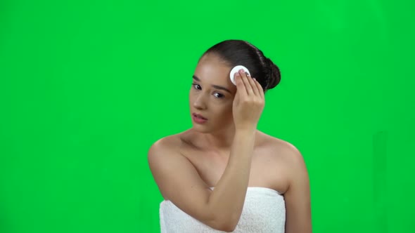 Woman with Bare Shoulders in White Towel Using Cotton Pad, Cleans Her Face. Slow Motion