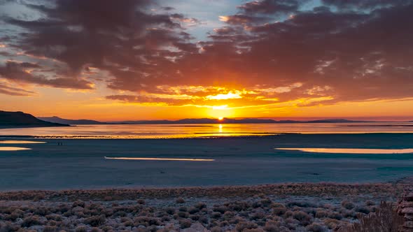 The sun sets beyond the shore of Antelope Island in Central Utah - panning time lapse of the Great S