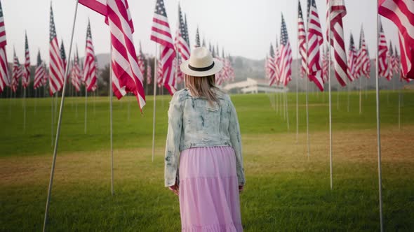 Beautiful Young Woman at with American Flags at Sunset