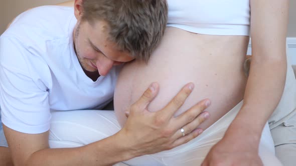 Future Dad Kissing Belly Of His Pregnant Wife. Closeup