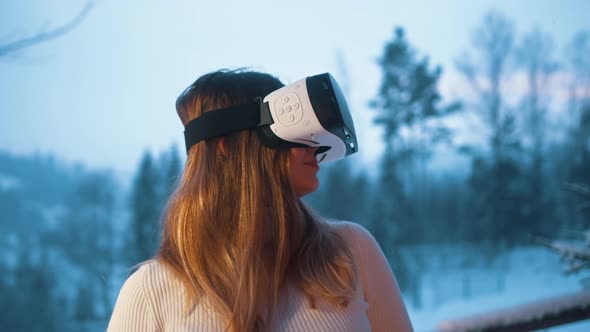 Young Caucasian Woman Vearing VR Glasses on the Terrace in Winter