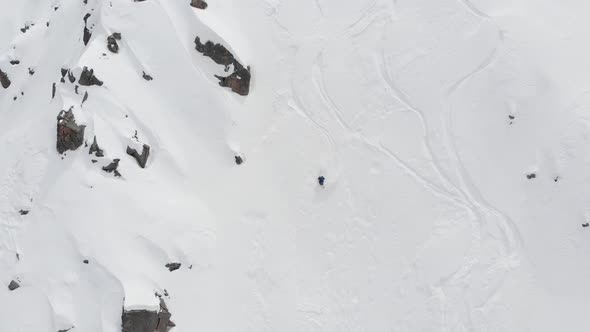 Aerial View of a Backcountry Skier Rides Freeride on a Steep Slope. Professional Ski Extreme in the