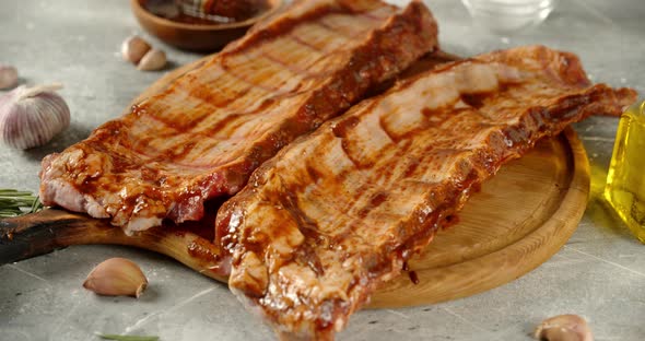 Raw Ribs on a Cutting Board with Garlic Slowly Rotate