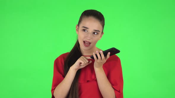 Portrait of Pretty Young Woman Is Asking for Information on the Network Via Phone. Green Screen