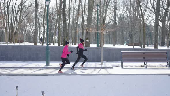 Fit Couple of Joggers Exercising in Winter Park