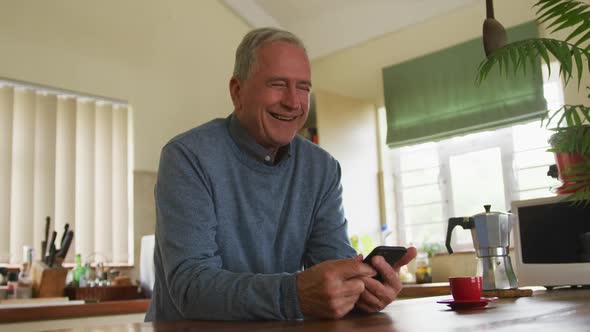 Senior man using mobile phone at home